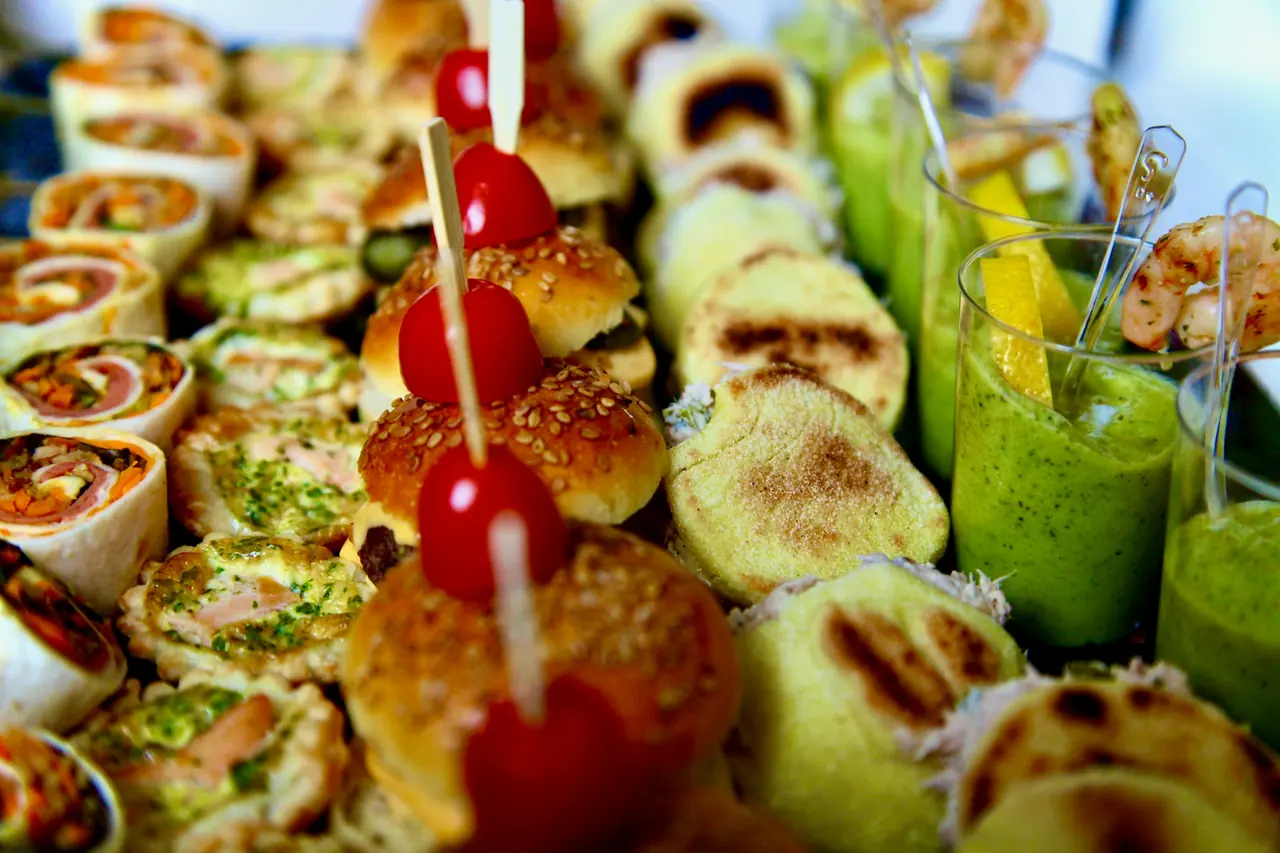 Große Platte mit BBQ-Fingerfood: gefüllte Wraps, gegrilltes Gemüse und Spieße