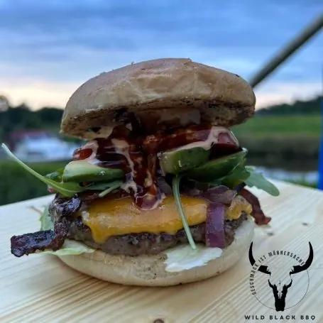 Hoch belegter Burger mit Cheddar und knusprigem Speck