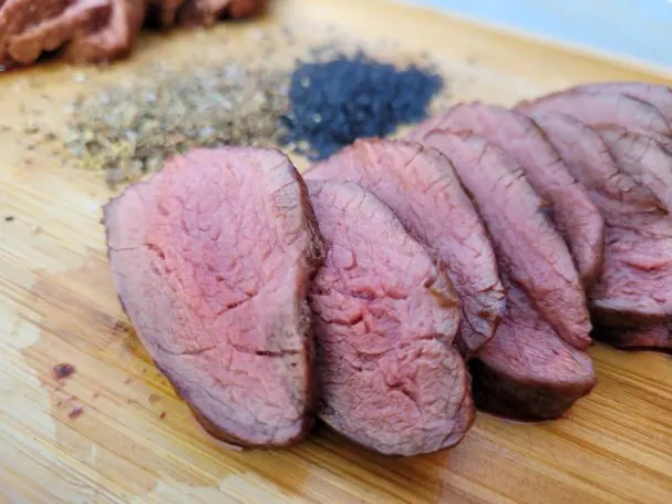 Aufgeschnittenes Roastbeef, rosa gegart, auf dunklem Grund