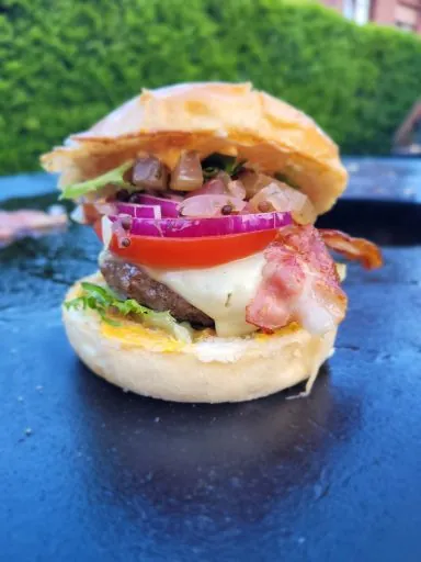Burger mit Speck, Tomate und roter Zwiebel auf der Plancha